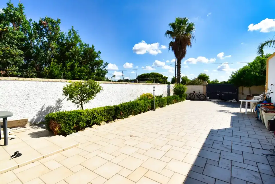 Open-plan living room with kitchen along one wall in the villa for sale in Punta Prosciutto