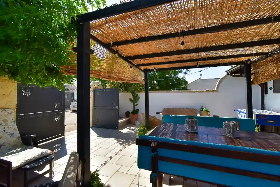 Private garden of the villa in Punta Prosciutto with shaded seating area and outdoor table